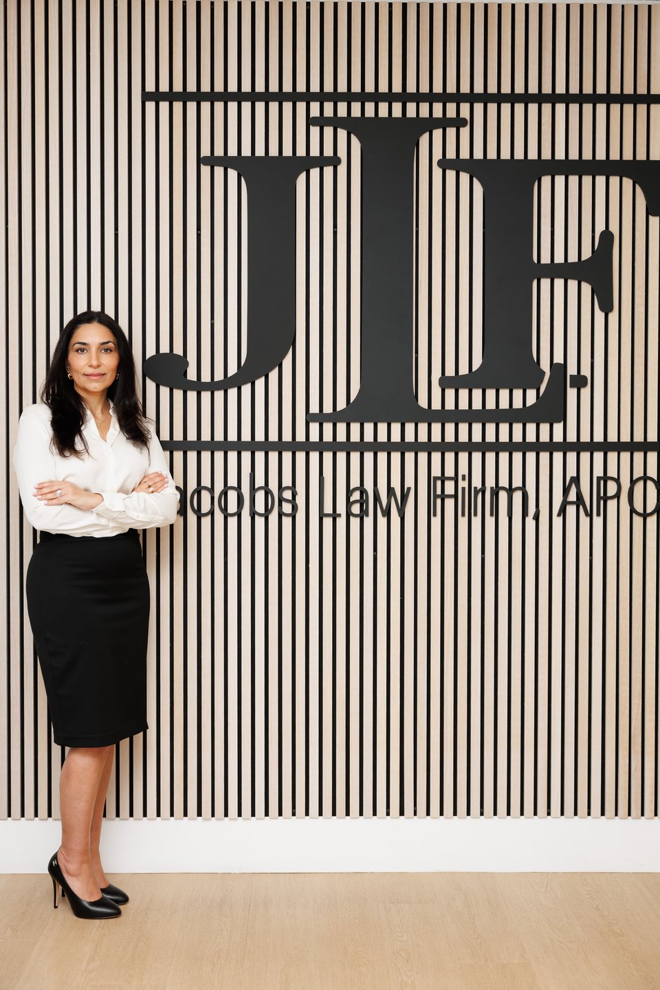 Attorney photographed at her Jacobs Law Firm branded wall