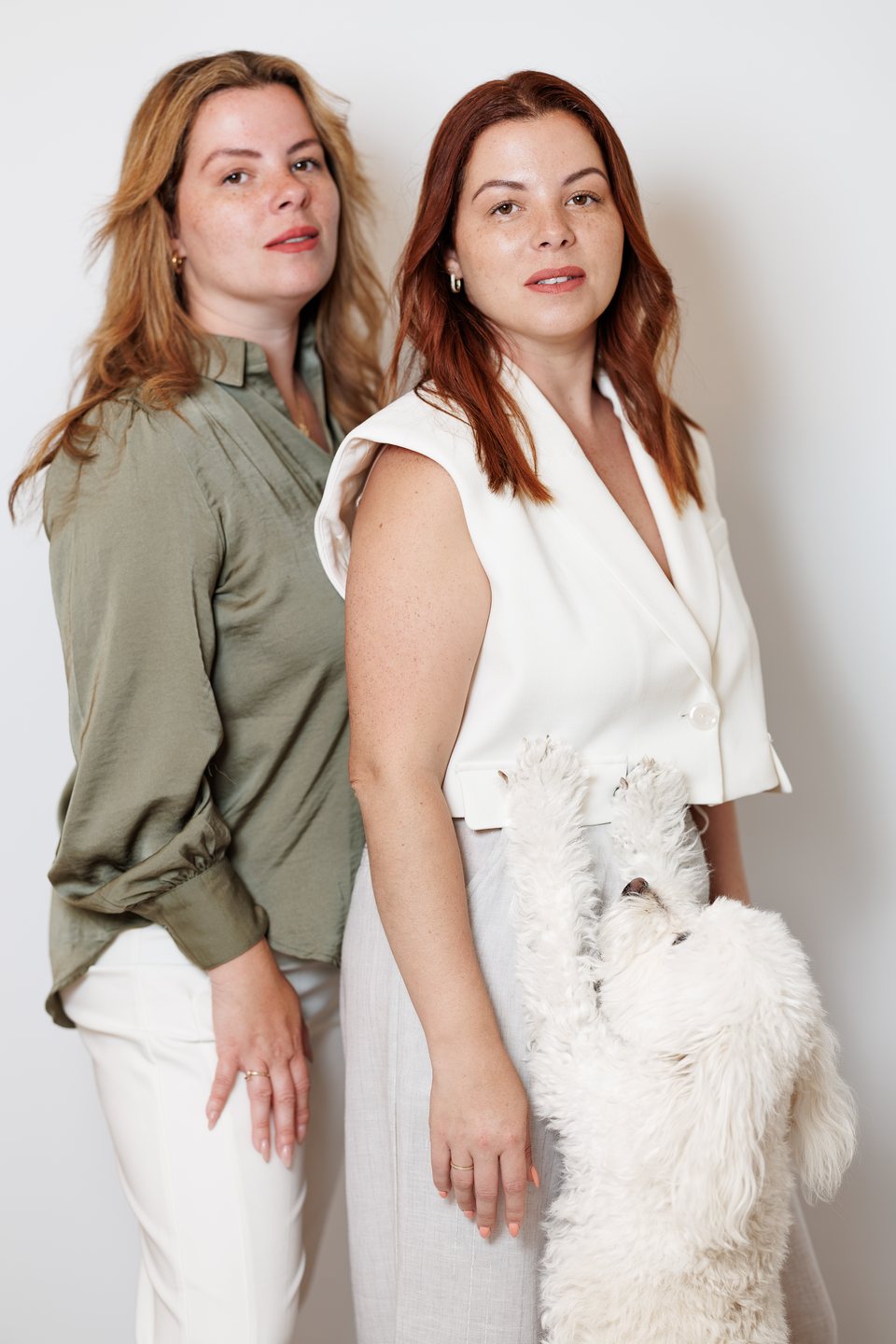 Two business partners photographed on-site with their office dog