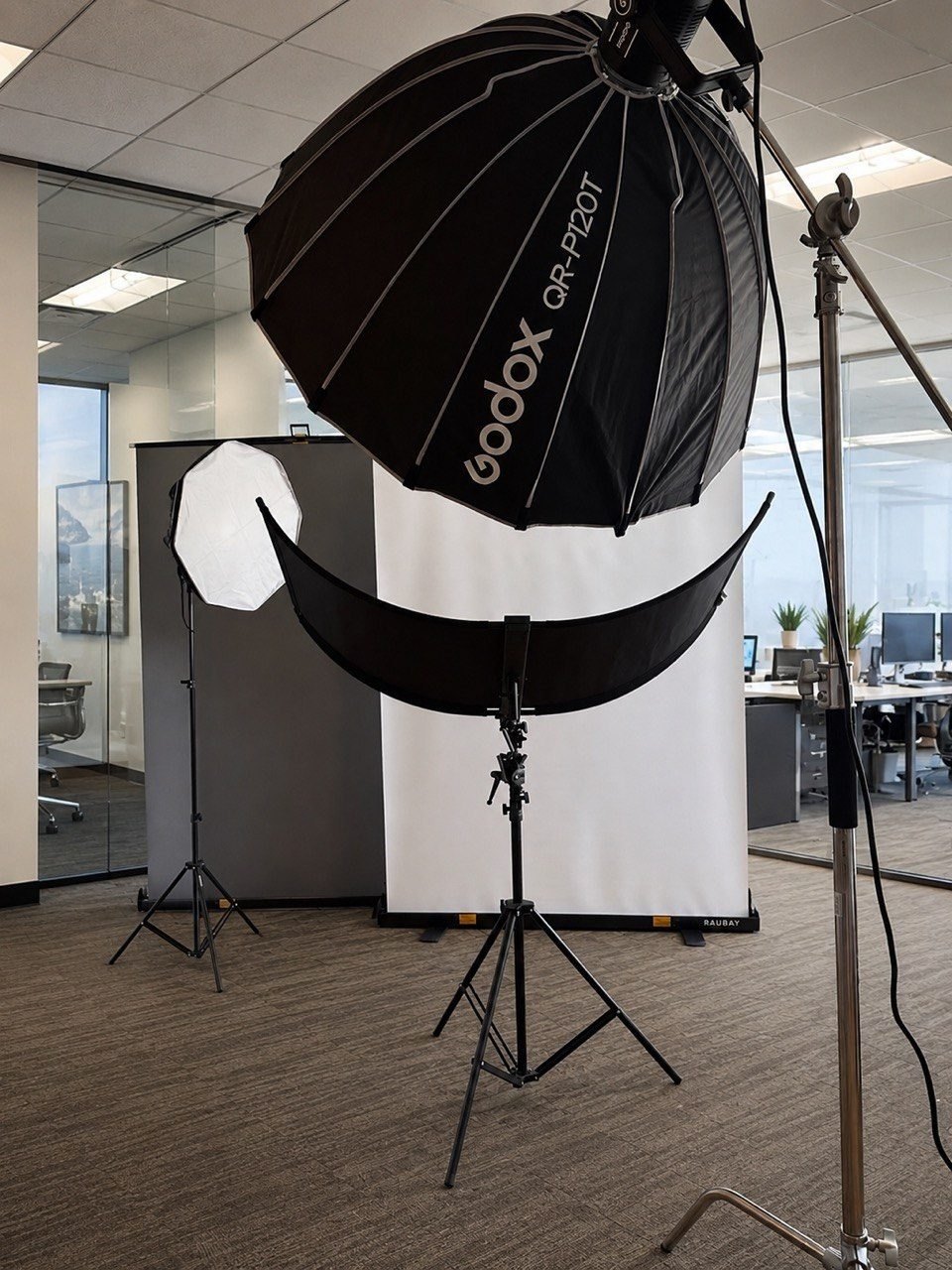 Anna's mobile photography studio — lighting, backdrop and reflector — set up inside a client's office